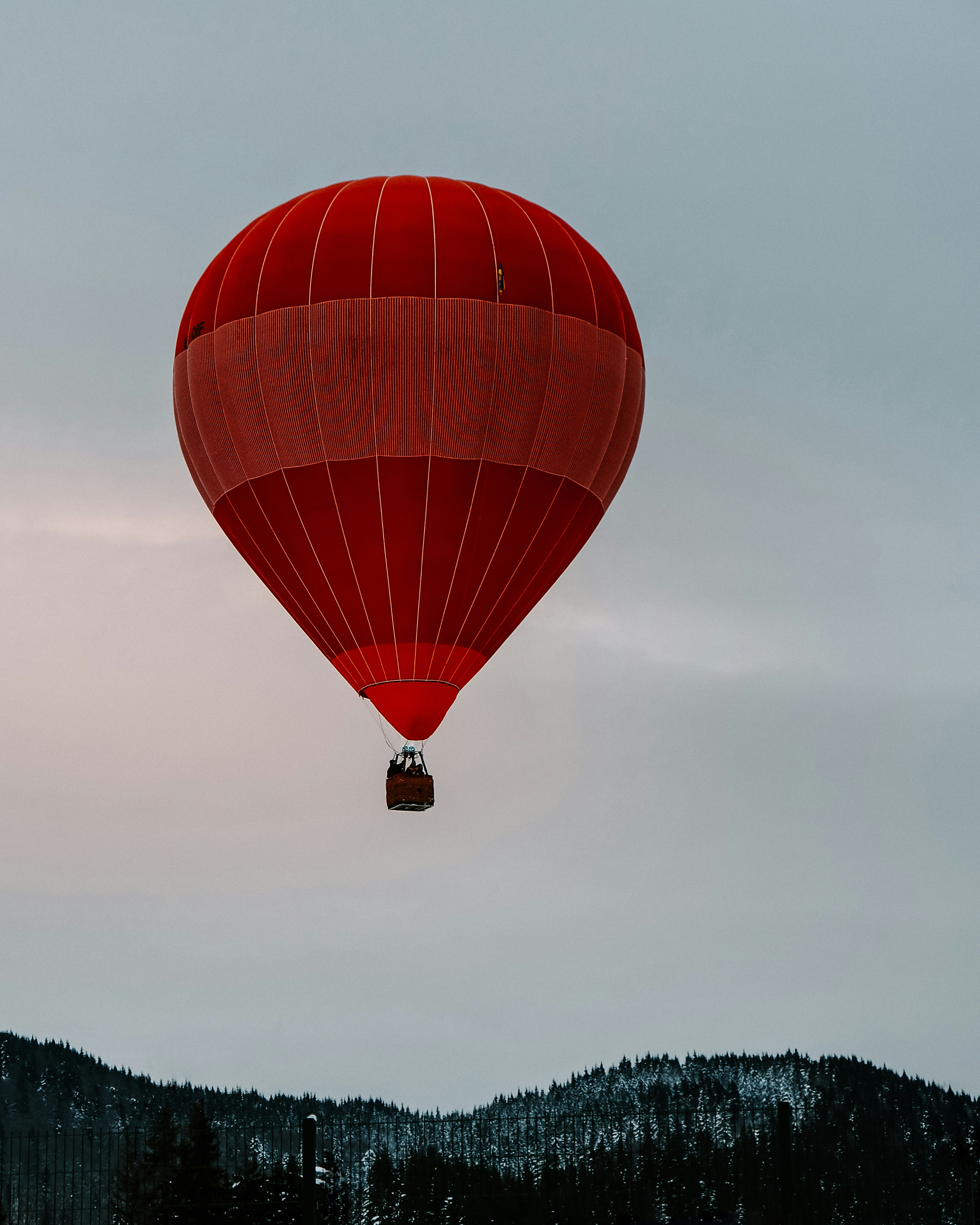 red hot air balloon on mid air during daytime